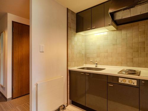 a kitchen with a sink and a counter top at AZUMINO KOGEN Resort in Azumino
