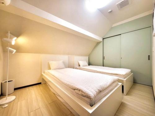 a small bedroom with two beds in it at New! Ten people Shin Ookubo 6minPocket WIFI in Tokyo