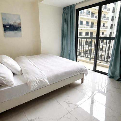 a bedroom with a bed and a large window at Sunnyplace Residences Near NAIA Airport in Manila