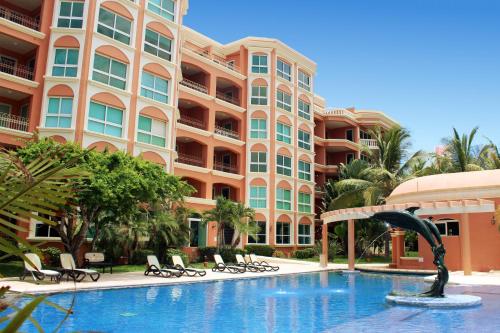 a swimming pool in front of a large building at Marina Costa Bonita in Mazatlán