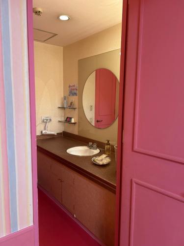 a bathroom with a sink and a mirror at HOTEL Gallery in Kobe