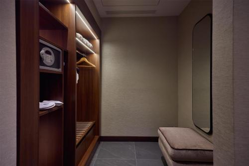 a walk in closet with a bench and a mirror at Hilton Milan in Milan