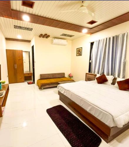 a bedroom with a large bed and a couch at Royal Hotel in Begūn