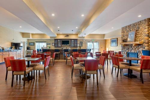 a restaurant with tables and chairs and a bar at Comfort Suites Anchorage International Airport in Anchorage