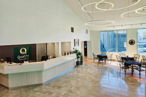 a lobby with a waiting area with tables and chairs at Quality Inn & Suites in Gatineau