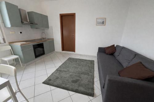 a living room with a couch and a kitchen at La casa di Lollo in Piombino