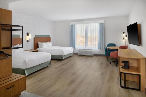a hotel room with two beds and a desk at Hampton Inn Midland West in Midland