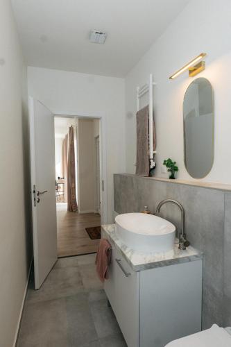 a white bathroom with a sink and a mirror at Wonder Bűbáj Mátrafüred in Gyöngyös