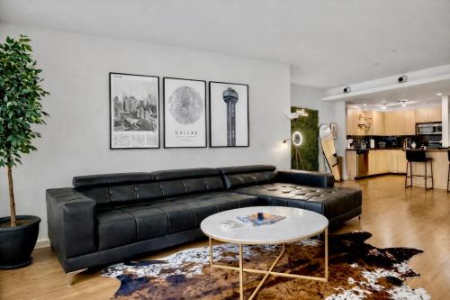 a living room with a black leather couch and a table at Modern Downtown Dallas City View High-Rise, Free Parking, Pool, Gym in Dallas