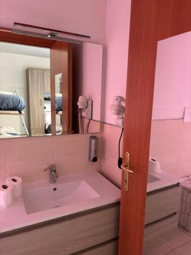 a pink bathroom with a sink and a mirror at GioIre Home Wellness in Como