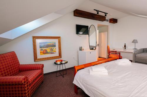 a bedroom with a bed and a chair and a mirror at Magnolia Tbilisi in Tbilisi City