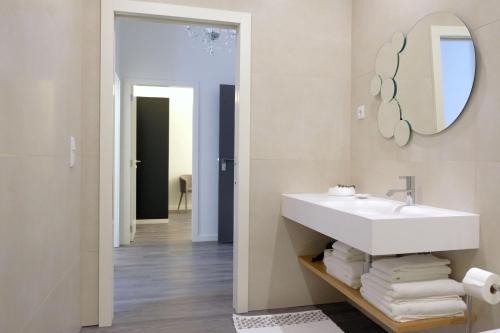 a bathroom with a white sink and a mirror at LETHESHOME Apartments in Porto