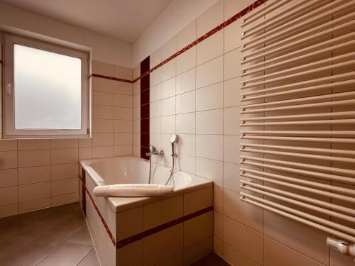 a bathroom with a tub and a sink and a window at Dünenhaus Lancken-Granitz in Lancken-Granitz
