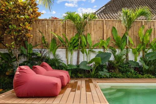 a pink bean bag chair sitting next to a swimming pool at Palermo Suites by DH in Ubud