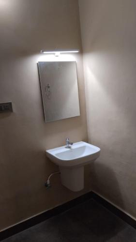 a bathroom with a sink and a mirror on the wall at Hotel Vimas International in Madurai