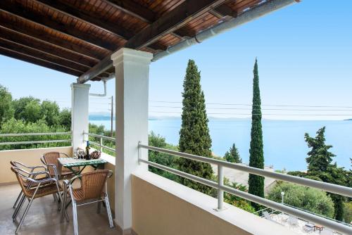 a balcony with a table and chairs and a view of the ocean at Hotel Barbati - Seaside Getaways with Pool in Barbati