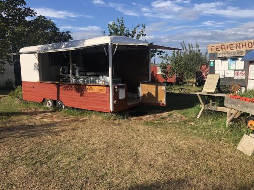 a red and white food truck parked in a field at Ferienhof Löbejün in Löbejün