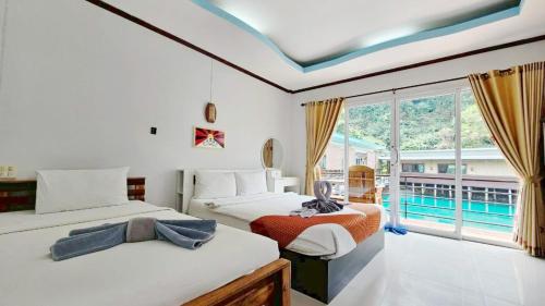 two beds in a room with a pool view at Lake Terrace Resort in Langu