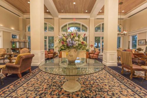 a lobby with a glass table with a vase of flowers at Cypress Bend Resort, a Wyndham Hotel in Many