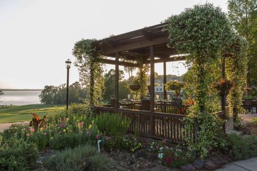 a gazebo with ivy and flowers in a garden at Cypress Bend Resort, a Wyndham Hotel in Many