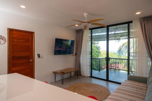 a living room with a ceiling fan and a balcony at v26 Sunset Dreams - Seaview in Haad Yao in Haad Yao