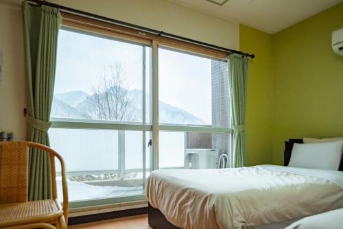 a bedroom with a bed and a large window at Fewdays Condominium608 in Sapporo