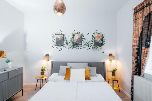 a bedroom with a white bed and some pictures on the wall at Wonder Mandragora Mátrafüred in Gyöngyös