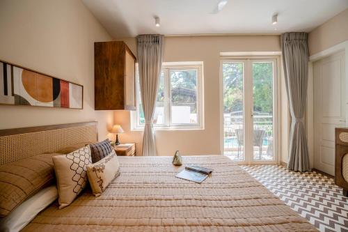 a bedroom with a large bed and windows at Staymaster Solintra - Serviced Apartment - Pool in Nerul