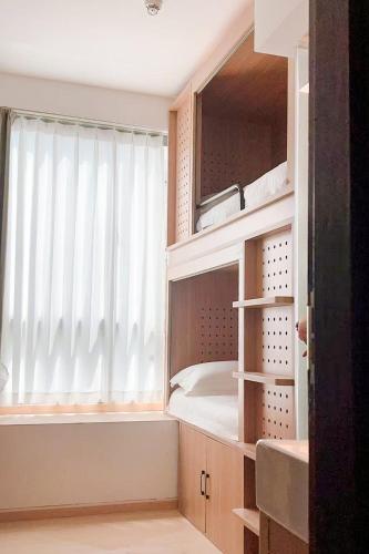 a room with a window with a bed and shelves at Homix Hotel in Singapore