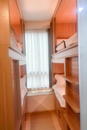 a small room with a window and some bunk beds at Homix Hotel in Singapore