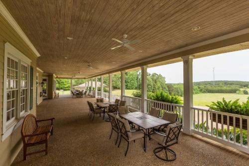 a screened porch with a table and chairs on it at Cypress Bend Resort, a Wyndham Hotel in Many