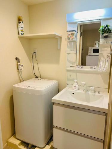 a small bathroom with a toilet and a sink at Le Amo吉塚 in Fukuoka