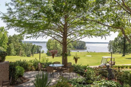 a patio with a table and chairs under a tree at Cypress Bend Resort, a Wyndham Hotel in Many