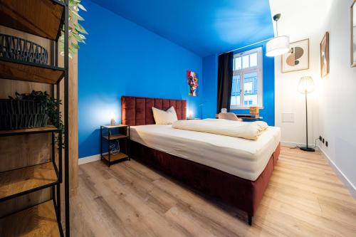 a bedroom with blue walls and a large bed at Pacmans Penthouse in Leipzig