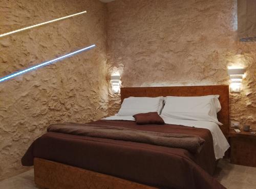 a bedroom with a bed in a stone wall at suite pompei La Caverna in Pompei