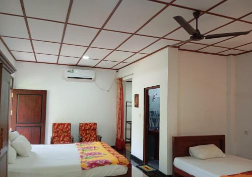 a room with two beds and a ceiling at Villa Sidu in Induruwa
