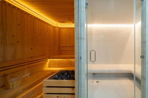 a sauna with a shower and a stove in it at Spoonamore Villa in Hang Dong