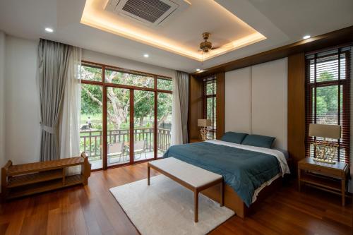 a bedroom with a bed and a balcony at Spoonamore Villa in Hang Dong