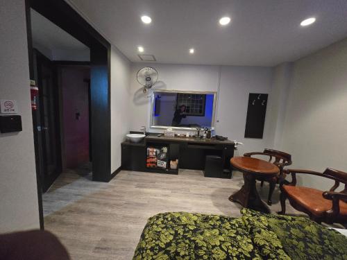 a living room with a tv and a table and chairs at 레이크모텔 in Tongsal-li