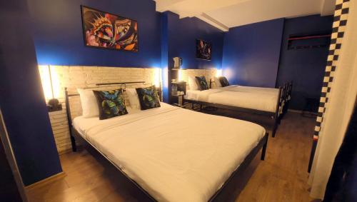 two beds in a room with blue walls at THINK HOTEL in Konya