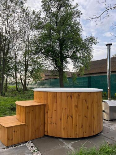 a wooden tub with a bench in a yard at Na.Zadkach in Klon