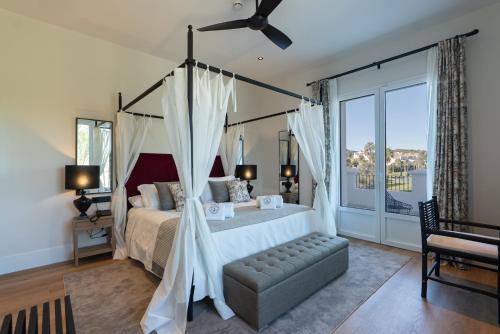 a bedroom with a large bed with a canopy at Hotel Duquesa Golf Club in San Luis de Sabinillas