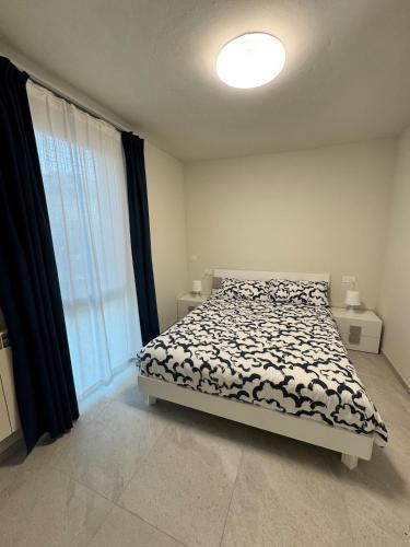 a bedroom with a bed and a large window at Appartamento DANTE in Pisogne