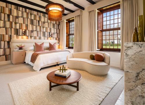 una camera da letto con un letto, un divano e un tavolo di Steenberg Hotel & Spa a Tokai