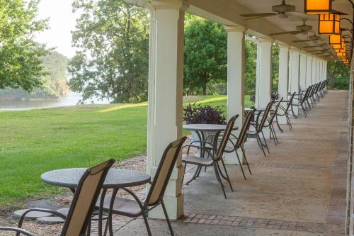 a row of tables and chairs on a porch at Cypress Bend Resort, a Wyndham Hotel in Many
