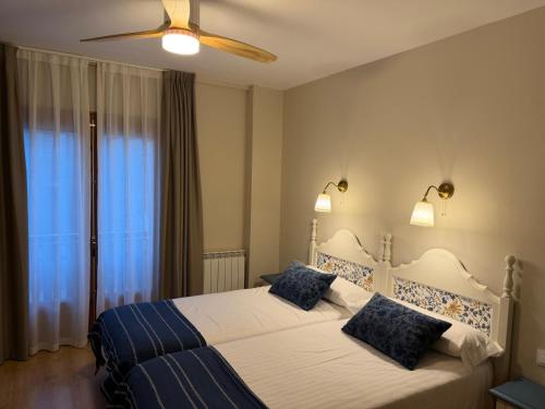 a bedroom with two beds and a ceiling fan at Edelweiss Hotel in Torla-Ordesa