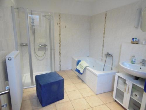 a bathroom with a shower and a tub and a sink at Ferienwohnung Schäfer in Waldbreitbach