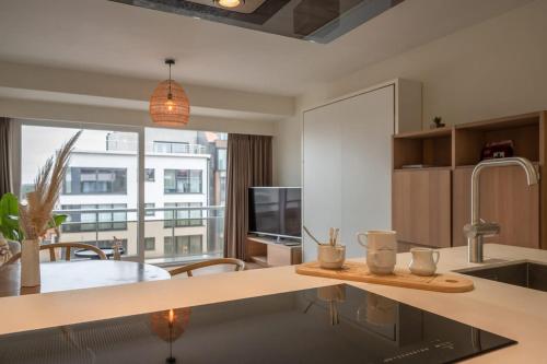 a kitchen with a table with two mugs on it at Modern Cozy Studio - Prime location Knokke in Knokke-Heist