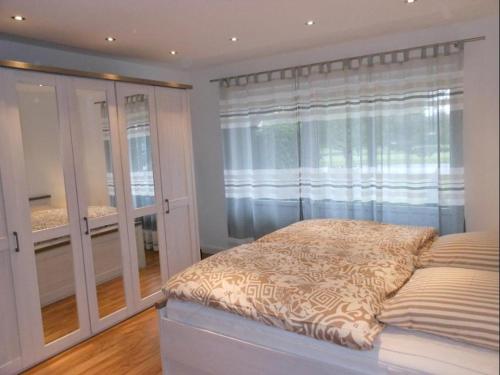 a bedroom with a bed and a large window at Golfresidenz B 007 in Grömitz