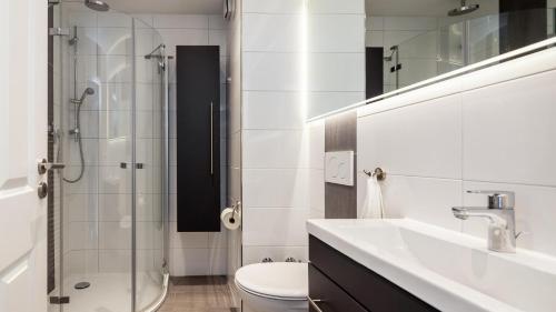 a bathroom with a toilet and a sink and a shower at Golfresidenz B 106 in Grömitz